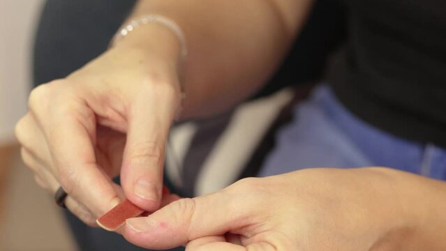 gros plan sur les mains d'une femme se limant les ongles