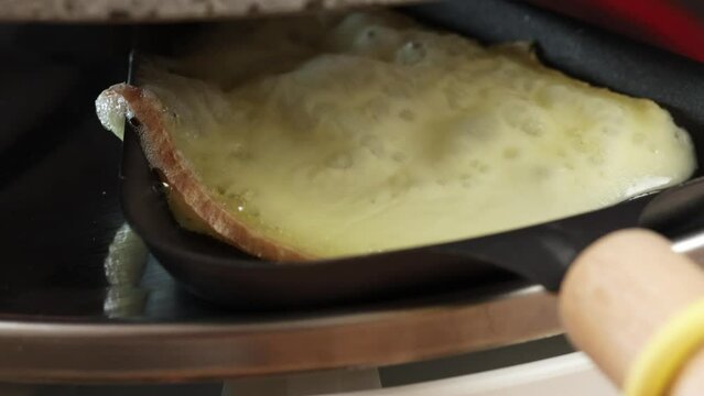 fromage en train de fondre dans un po&ecirc;lon d'appareil &agrave; raclette