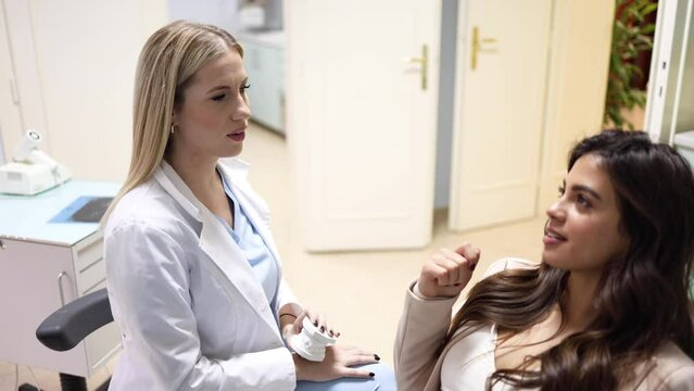 Young female dentist explaining the treatment to her female patient