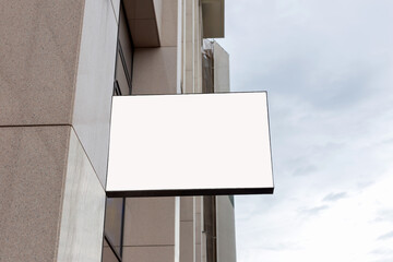 Empty white mockup on building facade against the sky