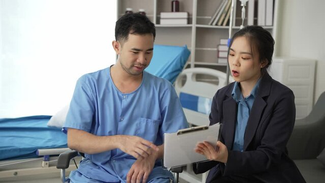 Young Asian female doctor and young male patient lying on bed while checking pulse Consult and explain with nurses taking notes and helping Video 4k