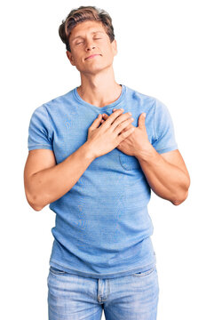 Young handsome man wearing casual clothes smiling with hands on chest with closed eyes and grateful gesture on face. health concept.