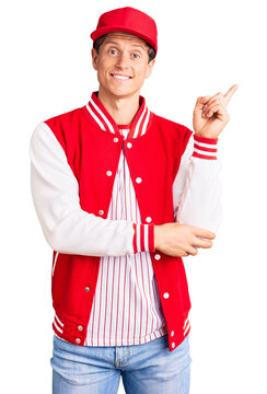 Young handsome man wearing baseball uniform smiling happy pointing with hand and finger to the side