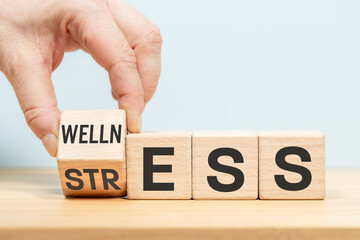 Stress or Wellness word concept on wooden cubes. Symbol of stress or well-being. Businessman hand turns the dice. blue background, copy space, business stress or well-being concept - 687569141