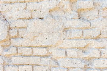 Abstract textured white wall background. Close-up view of old weathered brick wall with cement remains in a sunny day. Copy space for your text. Architecture backdrops theme.
