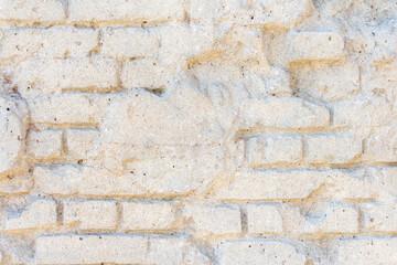 Abstract textured white wall background. Close-up view of old weathered brick wall with cement remains in a sunny day. Copy space for your text. Architecture backdrops theme.