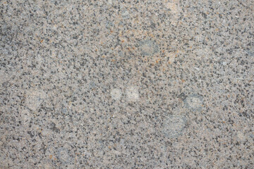 Abstract textured grey granite background. Close-up view of mottled stone surface. Soft focus. Copy space for your text or decoration. Real stone backdrop. Construction material theme. 
