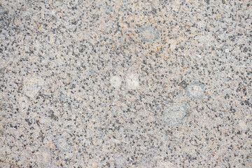 Abstract textured grey granite background. Close-up view of mottled stone surface. Soft focus. Copy space for your text or decoration. Real stone backdrop. Construction material theme. 