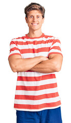 Young handsome man wearing casual clothes happy face smiling with crossed arms looking at the camera. positive person.