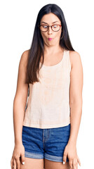 Obraz premium Young beautiful caucasian woman wearing casual clothes and glasses making fish face with lips, crazy and comical gesture. funny expression.