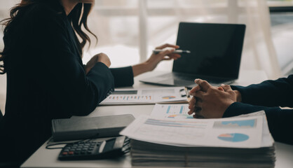 Financial analysts analyze business financial reports on a digital tablet planning investment project during a discussion at a meeting of corporate showing the results of their successful teamwork.