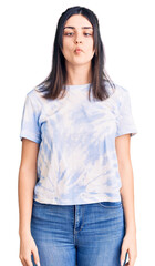 Obraz premium Young beautiful girl wearing casual t shirt making fish face with lips, crazy and comical gesture. funny expression.