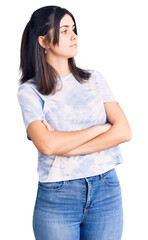Fototapeta premium Young beautiful girl wearing casual t shirt looking to the side with arms crossed convinced and confident