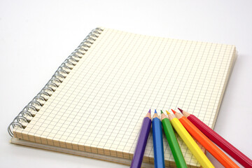 Colored pencils or pastel placed on graph book. Learning, study and presentation concept.