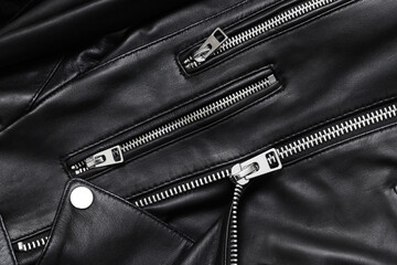 Black leather jacket background. Autumn clothing. Autumn winter fashion texture. Closed fastener. Zipped zipper. Fabric design pattern. Metal silver shiny zipper teeth background.