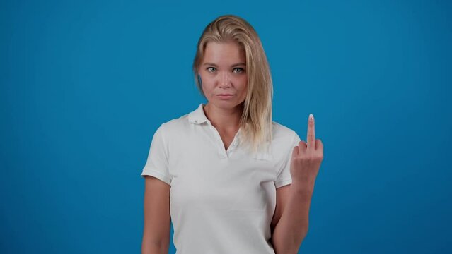 Young woman showing middle finger, gesture of fuck off. Young blonde girl shows a gesture of fuck. Expression negative, aggression, provocation. Emotions. People
