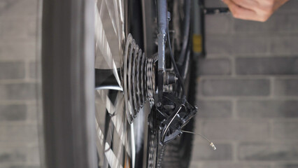 Close-up of the rotating brake disc and spokes of a mountain bike. Repair and maintenance of a bicycle in a specialised workshop.