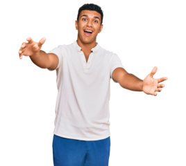 Young arab man wearing casual clothes looking at the camera smiling with open arms for hug. cheerful expression embracing happiness.