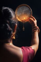 An Indian woman looking at the moon through a sieve during the Karwa Chauth festival.