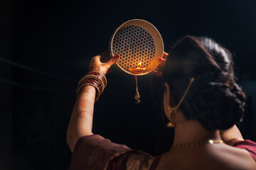 An Indian woman looking at the moon through a sieve during the Karwa Chauth festival.