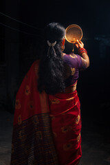 An Indian woman looking at the moon through a sieve during the Karwa Chauth festival.