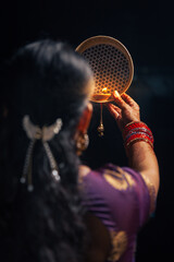 An Indian woman looking at the moon through a sieve during the Karwa Chauth festival.