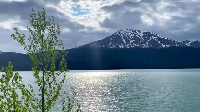 Kenai Lake (Dena'ina: Sqilan Bena) is a large, zig-zag shaped lake on the Kenai Peninsula, Alaska. The lake forms the headwaters of the Kenai River. Riding on the Alaska Railroad (ARR).