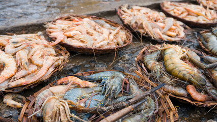 Baskets of fish and shrimps on display at a roadside market 