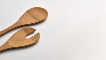 Closeup of two wooden spoons isolated on grey background.