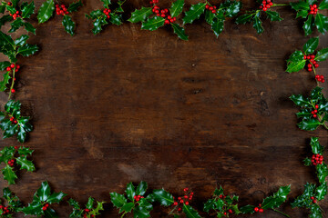 Christmas winter greenery and holly berry abstract background border on wooden bacground