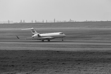 business jet aircraft landing on airport in black and white