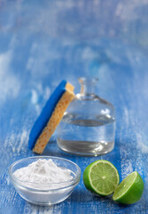 Baking soda, vinegar and cut lemons on white wooden table,