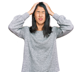 Beautiful asian young woman wearing casual clothes suffering from headache desperate and stressed because pain and migraine. hands on head.