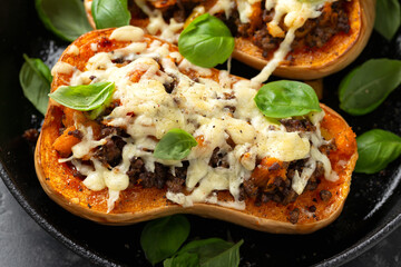 Baked Butternut Squash Pumpkin Stuffed with ground beef, vegetables and cheese in iron cast pan