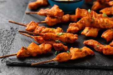 Grilled chicken fillet on skewers with white sauce on rustic stone board