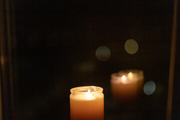 Burning candle near the window in the night city. Power outage due to war in Ukraine