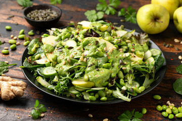 Super green salad with spinach, broccoli, apples, cucumber and edamame beans served with avocado,...