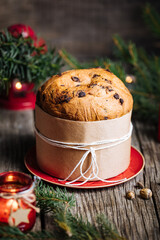 Christmas Panettone Cake with Melted Chocolate on Rustic Wooden Board and Festive Decorations - Holiday Dessert from Milan, Italy. 