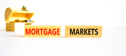 Mortgage markets symbol. Concept words Mortgage markets on beautiful wooden blocks. Beautiful white table white background. Wooden chest with coins. Business mortgage markets concept. Copy space.
