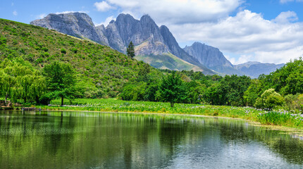 Panorama shot of Stark-Conde Wines lake and The Jonkershoek Mountains range in the background with...