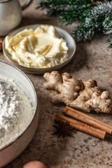 Baking ingredients for Gingerbread Cookies on brown kitchen table background. Flour, eggs, milk, honey, butter, spices