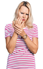 Young caucasian woman wearing casual clothes suffering pain on hands and fingers, arthritis...