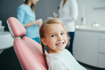 Cute smiling child girl after dental care or professional teeth cleaning in dentist office