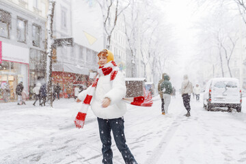 Positive portrait teenage girl in snowfall cityscape