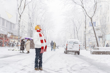 Positive portrait teenage girl in snowfall cityscape