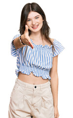 Young beautiful caucasian girl wearing casual clothes smiling friendly offering handshake as greeting and welcoming. successful business.