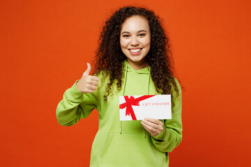 Young woman of African American ethnicity wear green hoody casual clothes hold gift certificate...