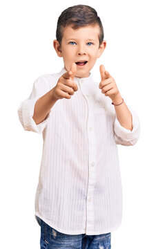 Cute blond kid wearing elegant shirt pointing fingers to camera with happy and funny face. good energy and vibes.