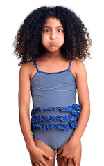 African american child with curly hair wearing swimwear puffing cheeks with funny face. mouth inflated with air, crazy expression. - obrazy, fototapety, plakaty