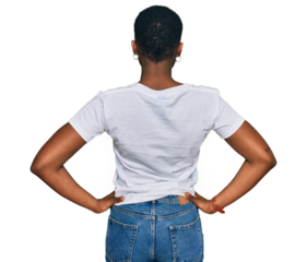 Young african american woman wearing casual white t shirt standing backwards looking away with arms on body